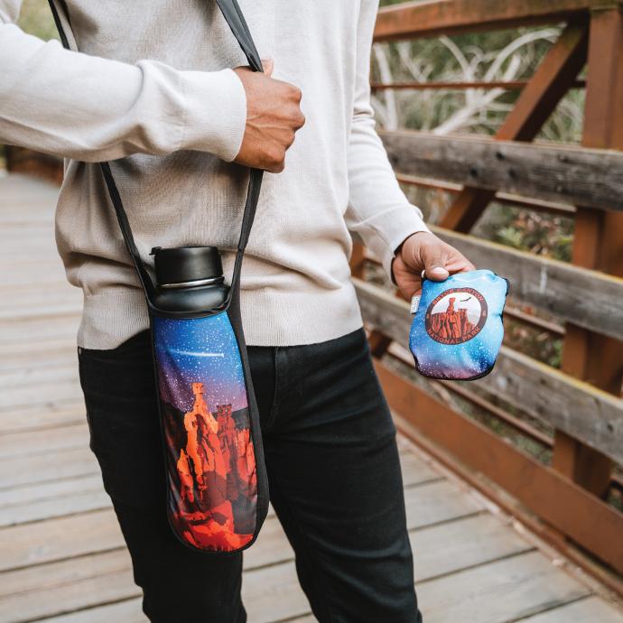 person on a bridge wearing a customized eco friendly ChicoBag reusable bottle sling bottle holder.
